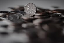 silver round coins on brown wooden surface
