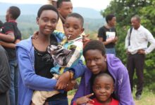 woman wearing blue jacket carrying a little boy